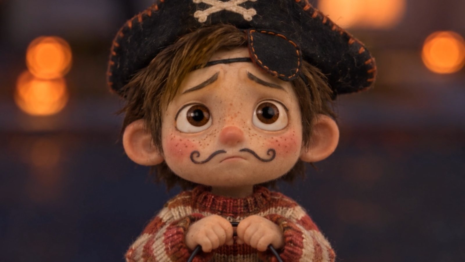 A little boy dressed as a pirate, with a drawn-on mustache, looks up in worry